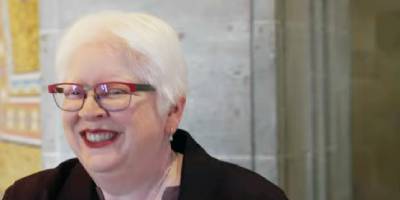 A person with a visual disability smiling in a bright indoor workspace